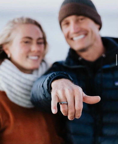 couple showing unique mens wedding band on hand