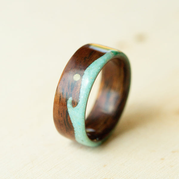 Wooden ring with a turquoise inlay on a beige background